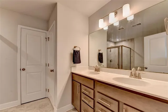 a bathroom with double vanity sinks and a mirror