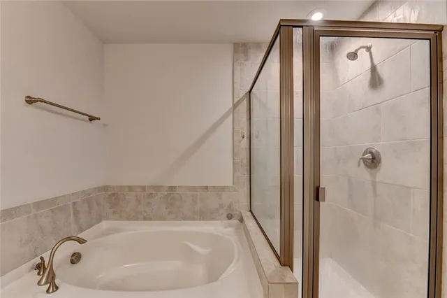 a bathroom with a white bath tub and shower