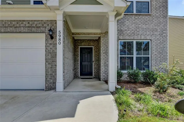 a front view of a house with a garden