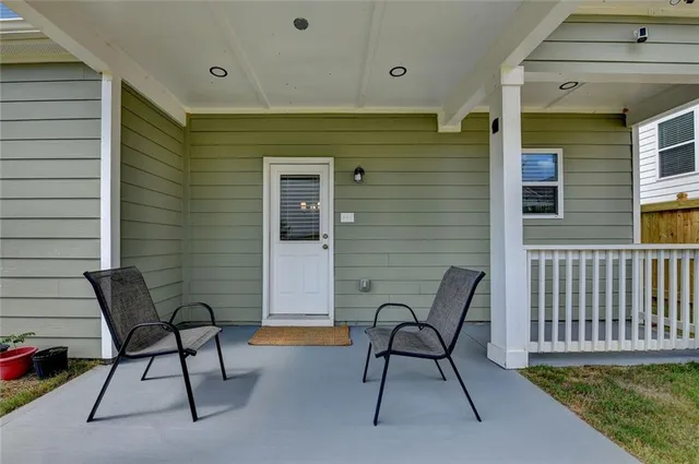 a balcony with table and chairs and a barbeque