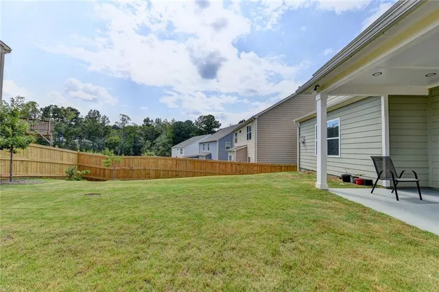 a backyard of a house with table and chairs