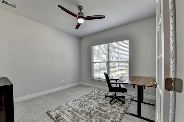 a view of a workspace with furniture and a window