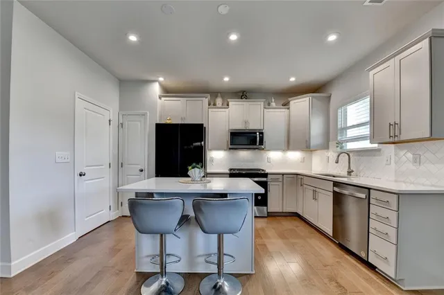a kitchen with stainless steel appliances kitchen island granite countertop a sink and cabinets