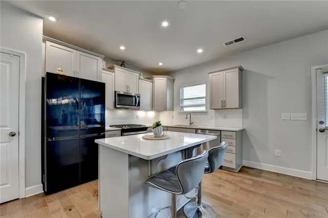 a kitchen with a refrigerator a stove top oven a sink and cabinets