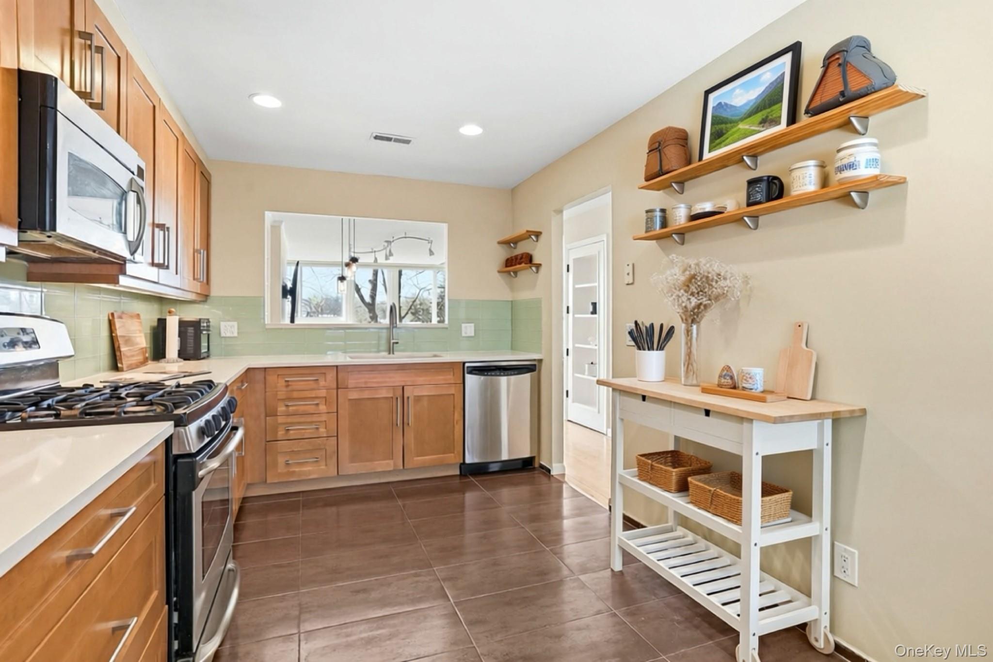 150 North Bedford Road, Unit 6D Chappaqua, NY 10514 - Photo 2 of 18 a kitchen with stainless steel appliances a stove a sink and a refrigerator