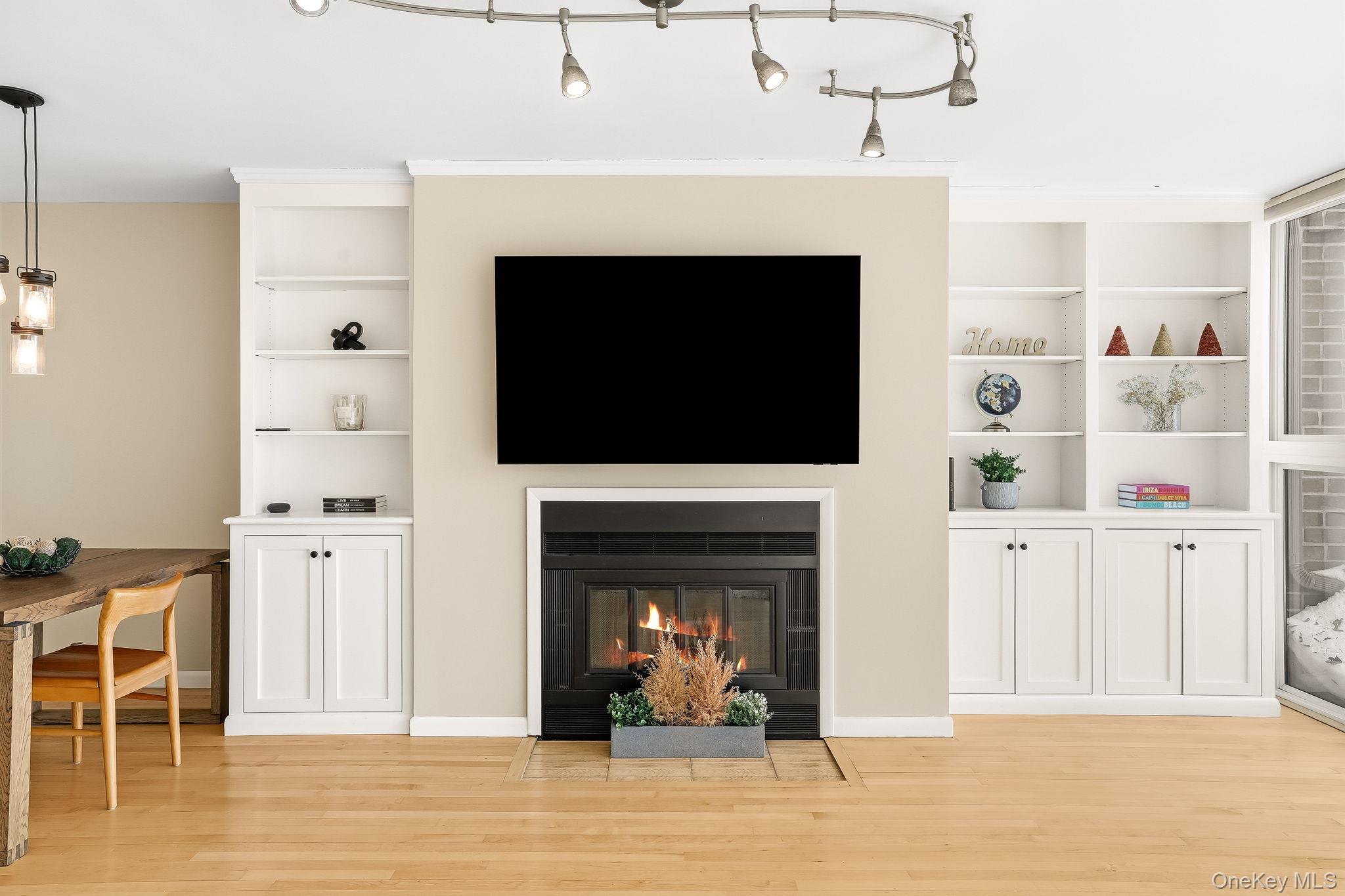 150 North Bedford Road, Unit 6D Chappaqua, NY 10514 - Photo 7 of 18 a living room with furniture a fireplace and a flat screen tv