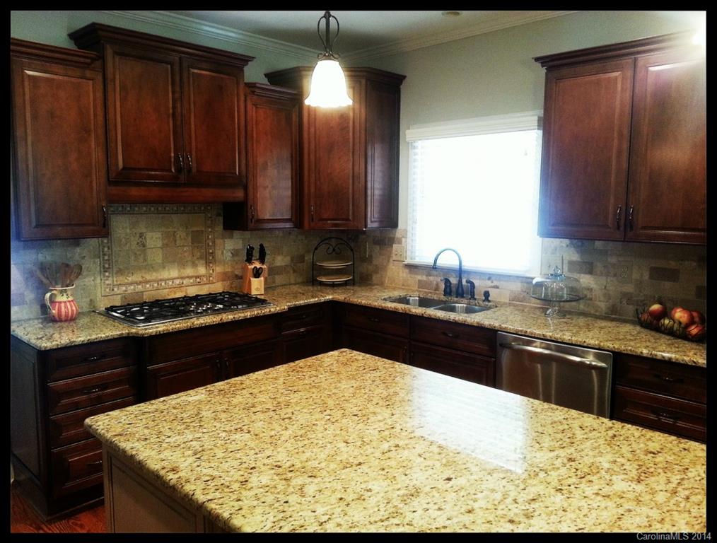 2420 High Ridge Road Charlotte, NC 28270 - Photo 5 of 24 a kitchen with a sink stove and wooden cabinets