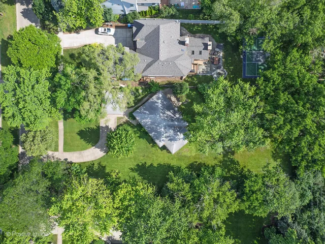 an aerial view of a house with a yard and lake view