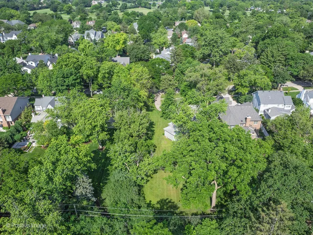 an aerial view of residential house with outdoor space and trees all around