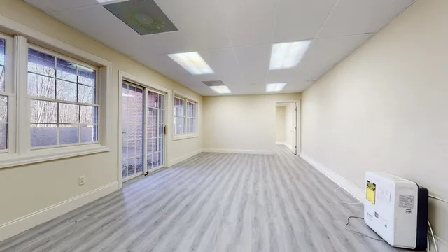 an empty room with wooden floor and windows