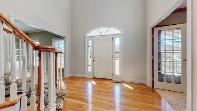 a view of an entryway with wooden floor and a livingroom
