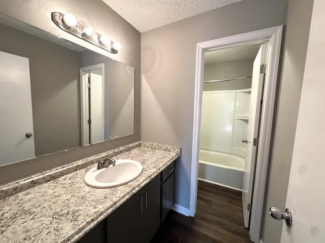 a bathroom with a granite countertop sink and a mirror