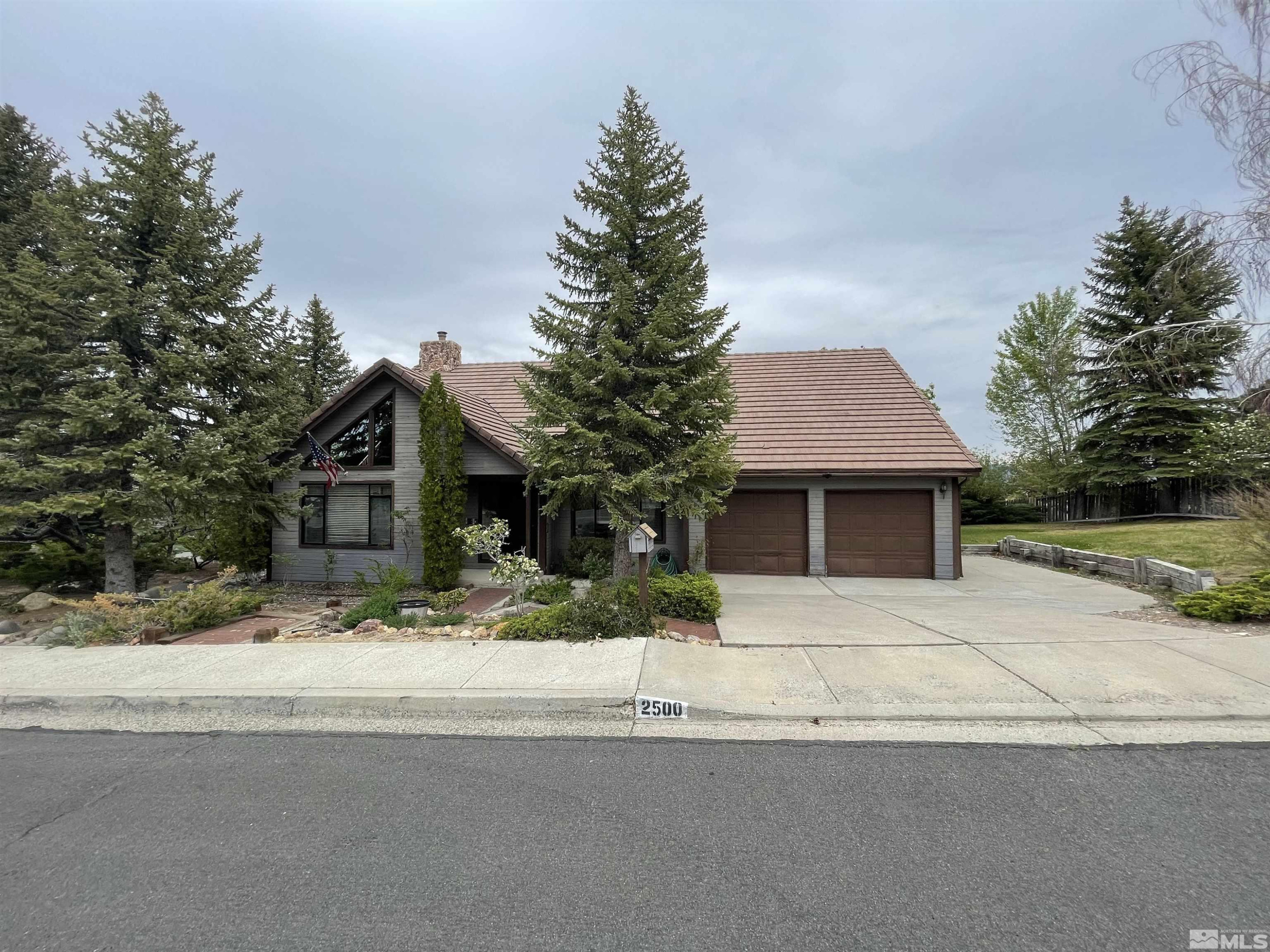 2500 Bryce Canyon Lane Reno, NV 89509 - Photo 2 of 23 a front view of a house with a yard and garage