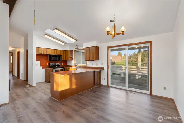 a view of a kitchen with wooden floor and a refrigerator