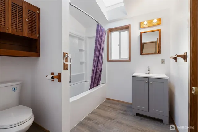 a view of an empty room with closet and a window