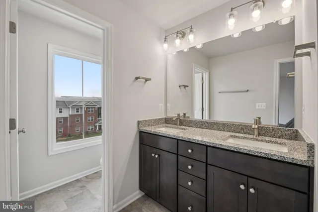 a bathroom with a granite countertop sink a large mirror and a vanity
