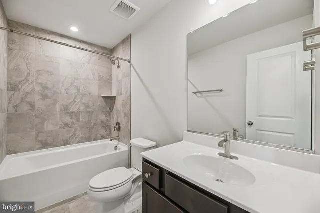 a bathroom with a sink toilet tub vanity and shower