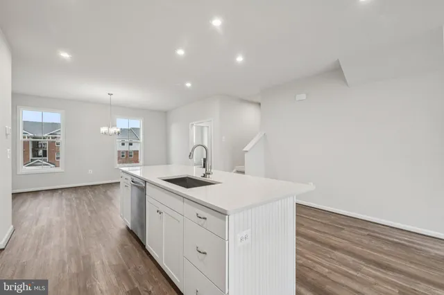a view of a kitchen counter space a sink wooden floor and a window