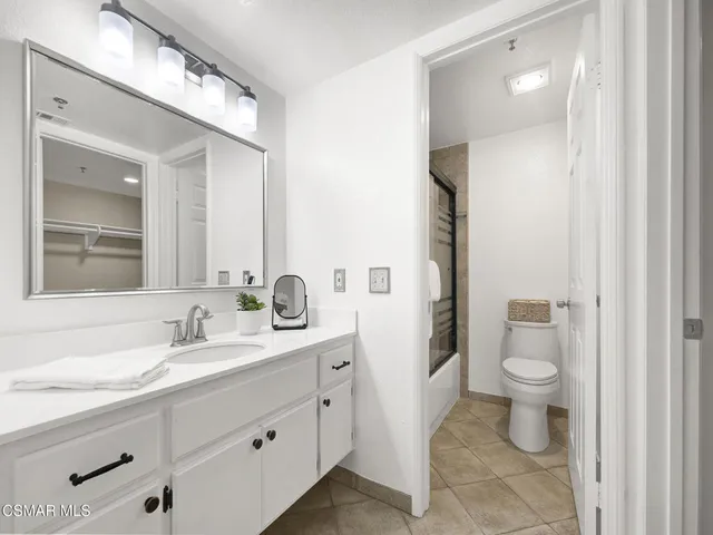 a bathroom with a double vanity sink toilet and shower