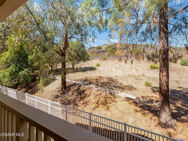 a view of a yard with wooden fence
