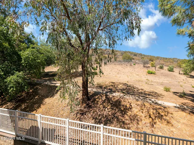 a view of a yard with wooden fence