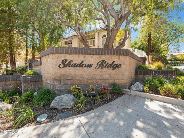 a sign that is sitting in front of flowers