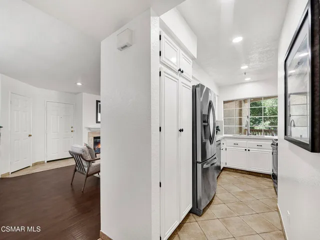 a large white kitchen with wooden floor and a window