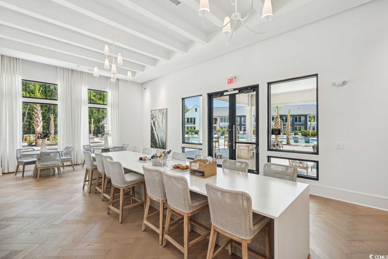 331 Pickwick Drive, Unit A2 Myrtle Beach, SC 29588 - Photo 36 of 39 Dining area featuring beam ceiling, light parquet flooring, and a notable chandelier