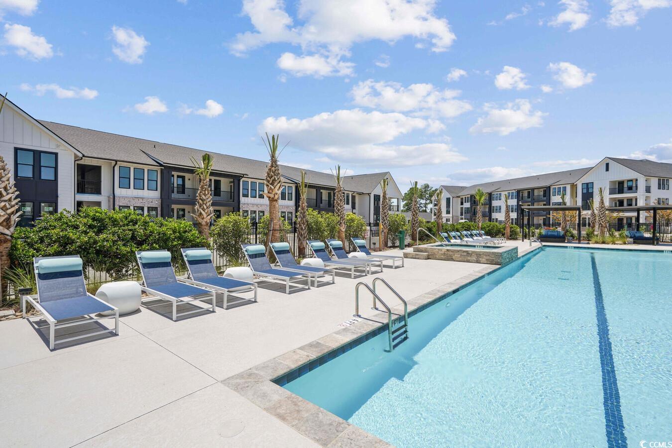 331 Pickwick Drive, Unit A2 Myrtle Beach, SC 29588 - Photo 6 of 39 View of swimming pool featuring a community hot tub and a patio