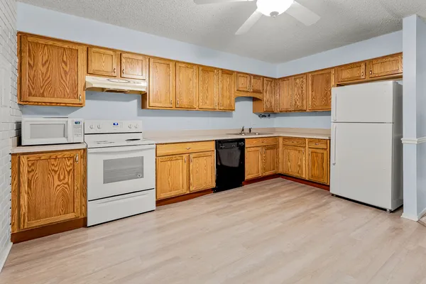 a kitchen with stainless steel appliances granite countertop a stove a sink dishwasher and a refrigerator