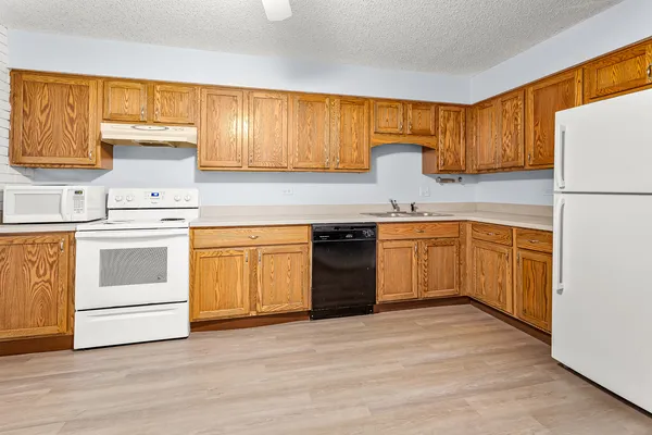 a kitchen with a stove sink and cabinets