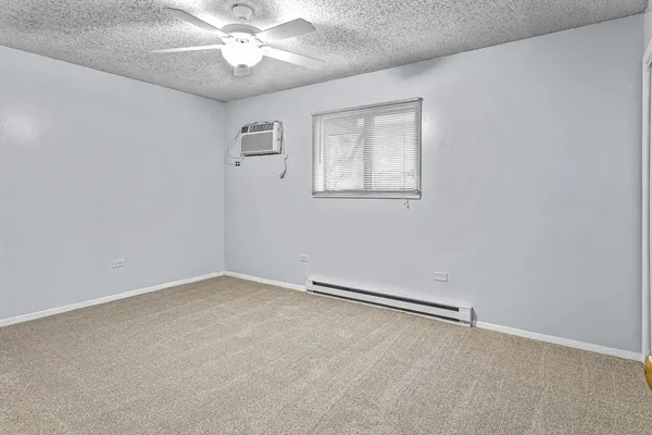 an empty room with a window and a ceiling fan