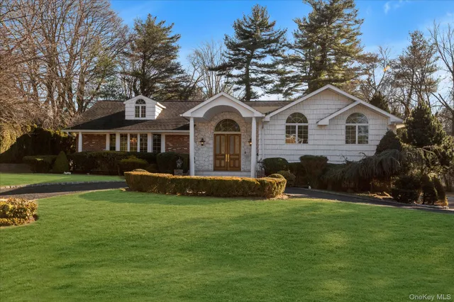 a front view of a house with a garden and yard