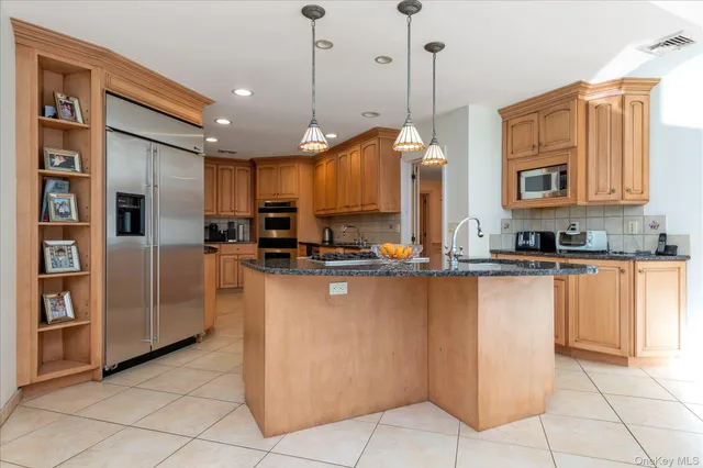 a kitchen with stainless steel appliances granite countertop a refrigerator a oven and a sink