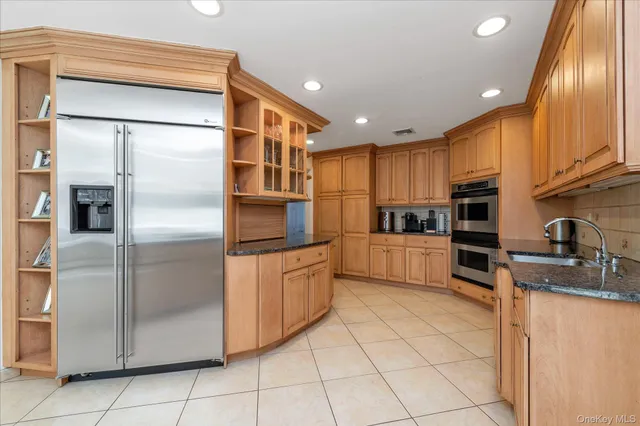 a kitchen with stainless steel appliances granite countertop a refrigerator and a stove top oven