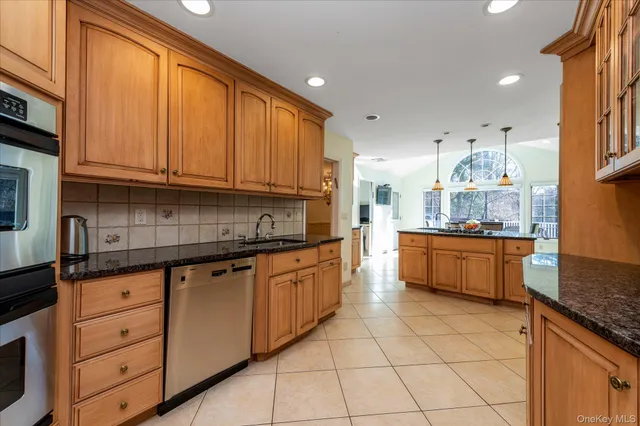 a large kitchen with stainless steel appliances granite countertop a stove a sink and a granite counter tops