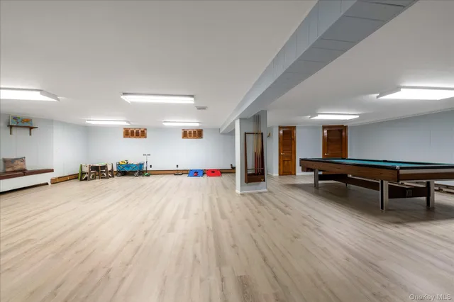 a room with wooden floor and pool table