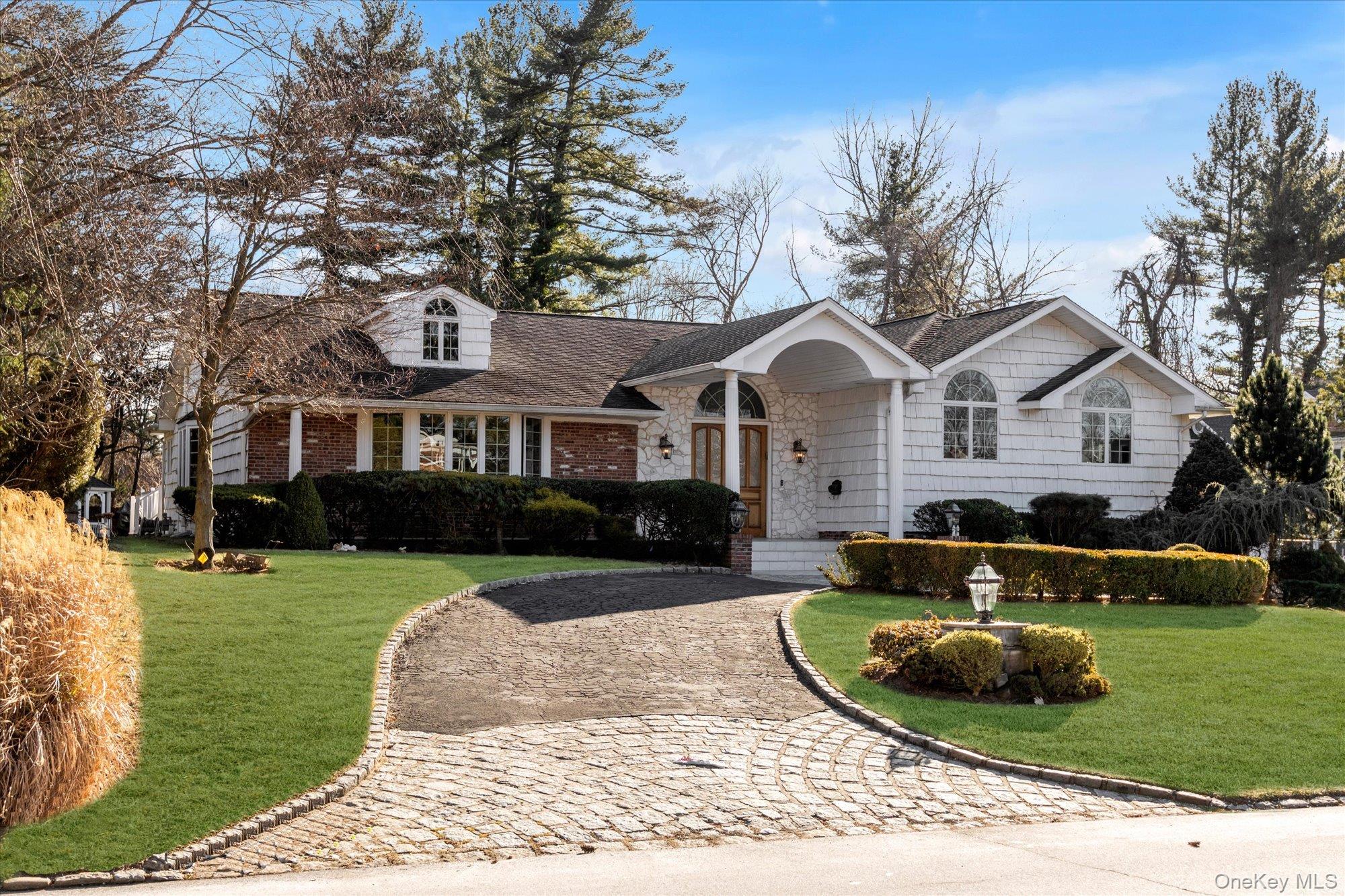 200 Hummingbird Drive East Hills, NY 11576 - Photo 3 of 29 a front view of a house with a yard table and chairs