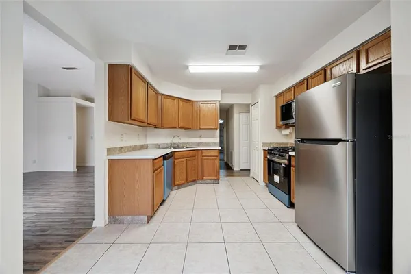 a kitchen with stainless steel appliances granite countertop a refrigerator and a stove top oven