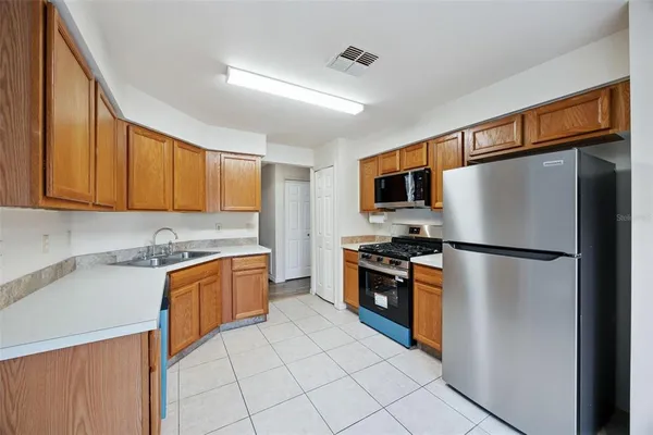 a kitchen with stainless steel appliances granite countertop a refrigerator stove top oven a sink and dishwasher