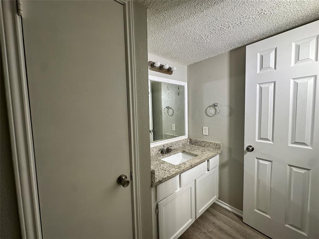 8109 Skillman Street, Unit 2007 Dallas, TX 75231 - Photo 17 of 25 a bathroom with a granite countertop sink and a mirror