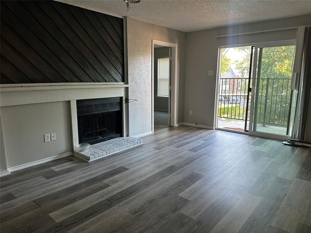 8109 Skillman Street, Unit 2007 Dallas, TX 75231 - Photo 2 of 25 an empty room with wooden floor fireplace and windows