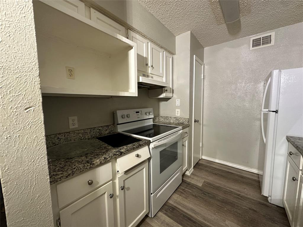 8109 Skillman Street, Unit 2007 Dallas, TX 75231 - Photo 6 of 25 a kitchen with granite countertop a stove and a refrigerator