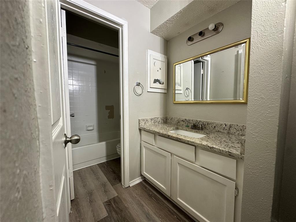 8109 Skillman Street, Unit 2007 Dallas, TX 75231 - Photo 8 of 25 a bathroom with a granite countertop sink a mirror and a shower