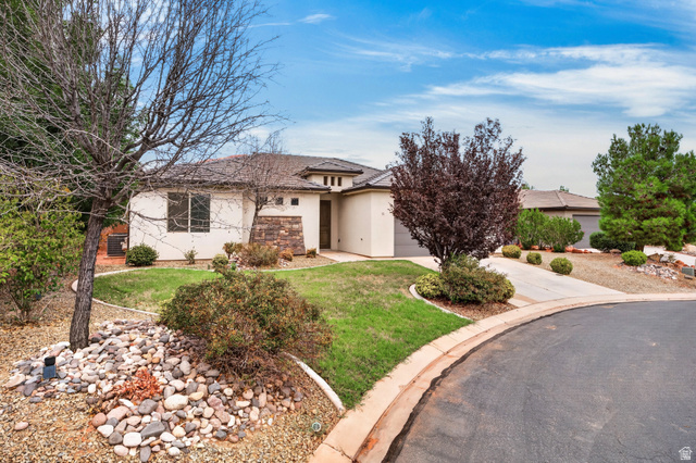 11 East 640 South Ivins, UT 84738 - Photo 44 of 44 Stucco exterior with stone accents, a landscaped front yard with mature plantings, and a paved driveway