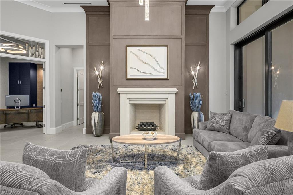18410 Blue Eye Loop Fort Myers, FL 33913 - Photo 16 of 49 Living room with soaring 18' vaulted ceilings, custom lighting fixtures, natural gas fireplace with custom 16' white oak walls and impact sliders with transom windows.