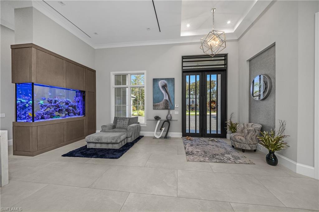 18410 Blue Eye Loop Fort Myers, FL 33913 - Photo 18 of 49 Grand entry with Suncoast double iron front door with transom window, and a custom dual-sided 400 gallon saltwater tank with white oak wood accent.