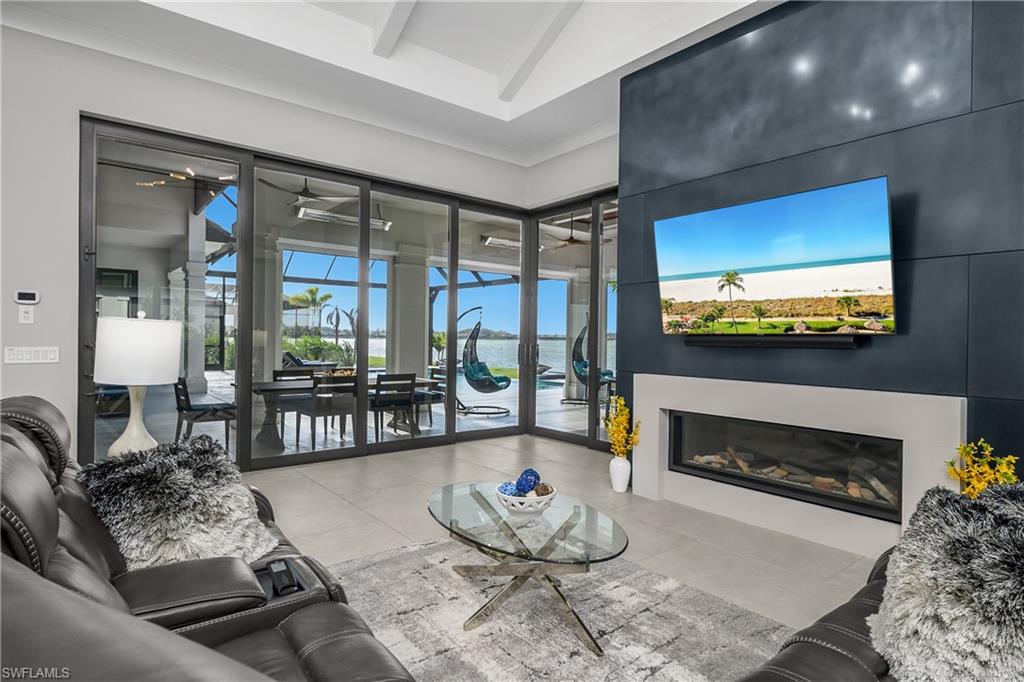 18410 Blue Eye Loop Fort Myers, FL 33913 - Photo 20 of 49 Family room natural gas fireplace is finished with a stainless steel metal patina accent wall and surrounded by walls of glass sliders.
