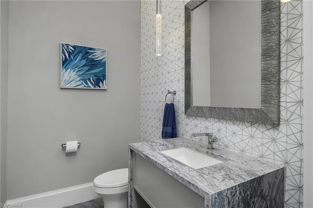 18410 Blue Eye Loop Fort Myers, FL 33913 - Photo 34 of 49 Pool bath with outdoor entry features intricate tile detail and leathered counter vanity sink.