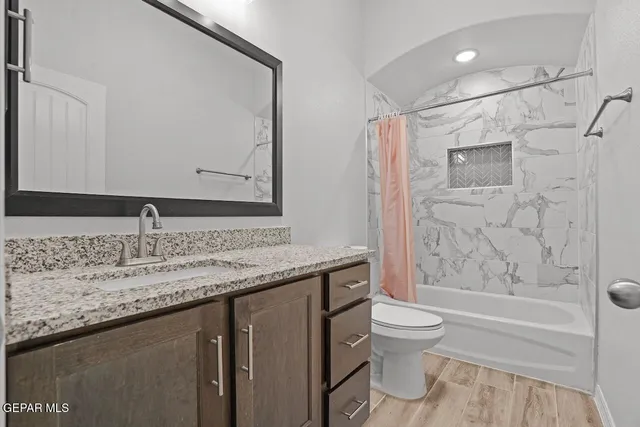 a bathroom with a granite countertop sink toilet and shower